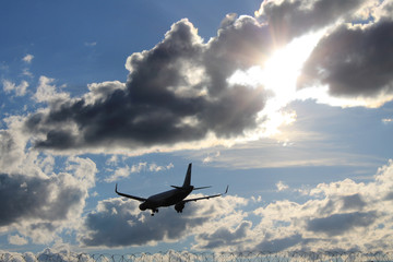 Fototapeta na wymiar Flying plane in the blue sky with clouds
