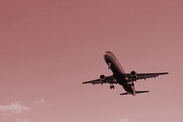 Flying plane in the blue sky with clouds