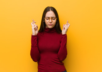 Intellectual young girl crossing fingers for having luck