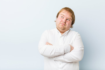 Young authentic redhead fat man unhappy looking in camera with sarcastic expression.