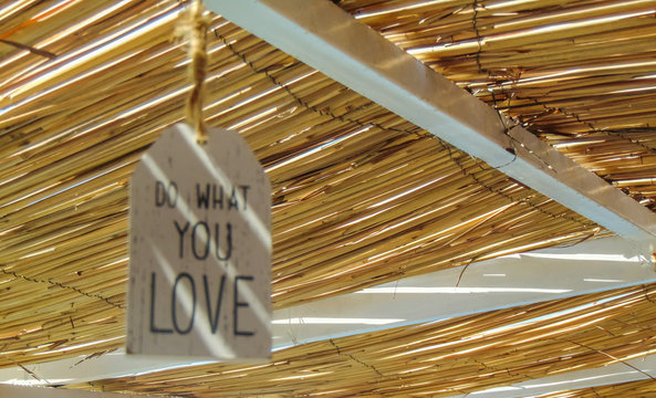 Do what you love inspirational quote hanging on the straw roof .