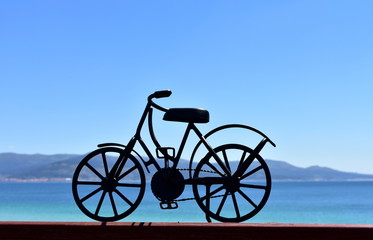 Fototapeta na wymiar Beach with black iron bicycle. Galicia, Spain.