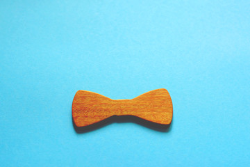 Happy Father's Day! Wooden bow tie on blue background. Place for your text.