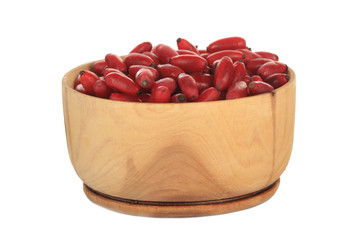 heap of red fresh barberry in wooden cup isolated on white background