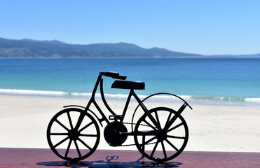 Fototapeta na wymiar Beach with black iron bicycle. Galicia, Spain.