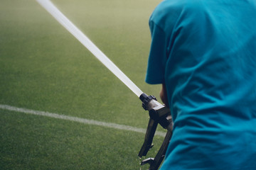 Grass field sprinklers installation by professional caucasian garden systems installator. watering the sports stadium concept
