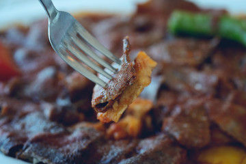 traditional turkish iskender kebab on a wooden surface at restaurant