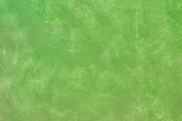 Wall background with lime-green paint strokes. The texture of the wall with brush strokes of lime-green paint. Abstract colorful background for the holiday.