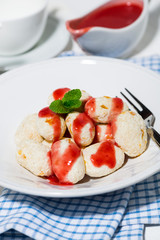 cottage cheese dessert with strawberry sauce, vertical closeup