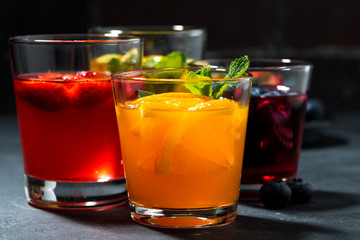 fruit lemonades in assortment on dark table, closeup