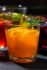 fruit lemonades in assortment on dark table, vertical closeup