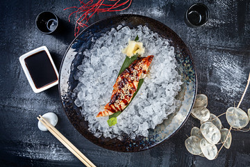 Top view on fresh sliced eel sashimi served in bowl with ice on dark background. japanese food sashimi. Japan restaurant menu. Copy space for design. Top view seafood. Healthy meal - obrazy, fototapety, plakaty