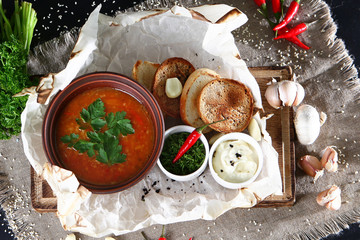 Ripe tomato soup with croutons and dressings. View from above. Still life concept