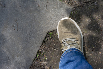 Close-up of legs in walking shoes against the background of the ground. Walk in the park.