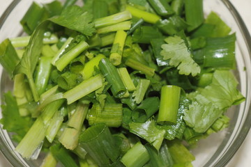 Glass bowl of cilantro and chives sliced. Ingredients to make a healthy dish 