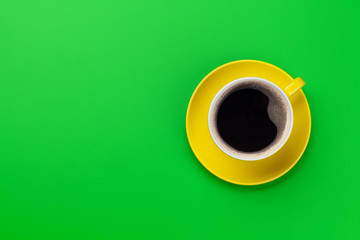 Yellow coffee cup over green background