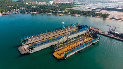 Fototapeta premium Aerial view shipyard have crane machine and container ship in black ocean