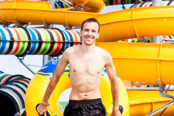 excited man having fun on water slide in tropical aqua park