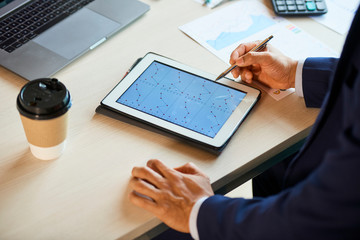 Hands of Entrepreneur analyzing charts with statistics on tablet computer
