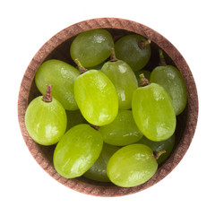 green grapes in wooden cup isolated on white. top view