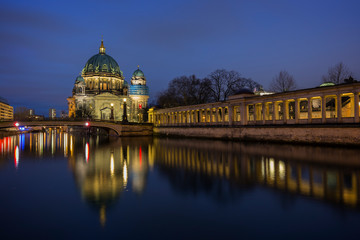 Fototapeta na wymiar Beautiful view of the illuminated Berliner Dom (Berlin Cathedral) and colonnade on the Museum Island and reflections on the Spree River in Berlin, Germany, at dusk.