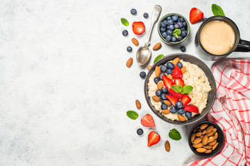 Oatmeal porridge with fresh berries and nuts top view. 