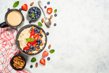 Oatmeal porridge with fresh berries and nuts top view. 