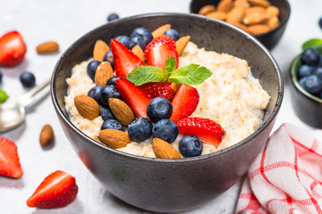 Oatmeal porridge with fresh berries and nuts. 
