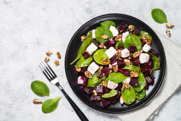 Fresh salad from spinach, beet and feta cheese with walnut.