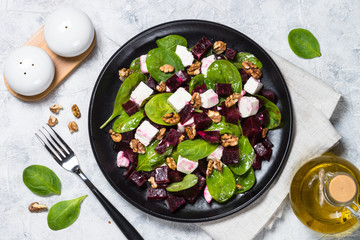Fresh salad from spinach, beet and feta cheese with walnut.