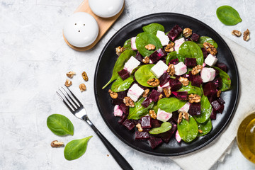 Fresh salad from spinach, beet and feta cheese with walnut.