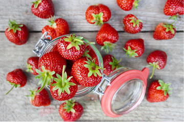  A jar filled with red, ripe strawberries
