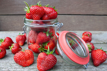 A jar filled with red, ripe strawberries