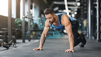 Fototapeta na wymiar Muscular guy preparing for hard workout in gym