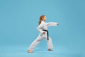 Karate girl with black belt practicing martial arts. 
