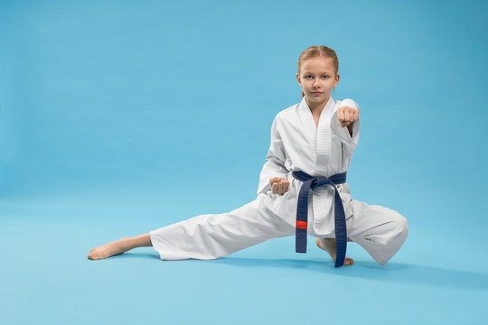 Karate girl standing in stance and training punching.