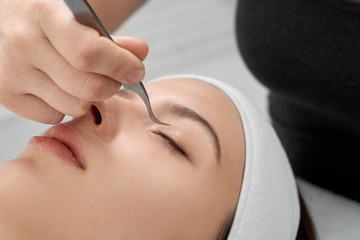 Woman undergoing eyelash extensions procedure.