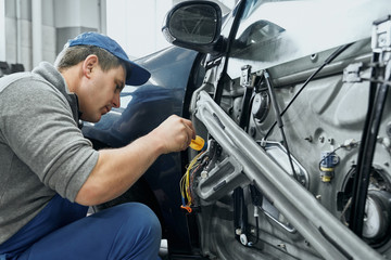 Side view of auto mechanic repairing electrical wires