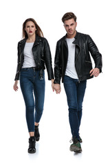 Fototapeta premium Determined couple stepping forward and holding hands
