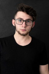 Fototapeta premium Studio shot of young handsome casual businessman against the black background.