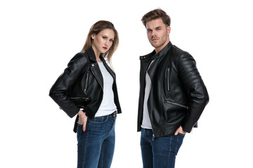 Tough couple standing with their hands in their back pockets