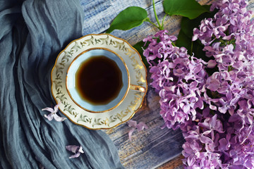 Obraz na płótnie Canvas Tea in a blue Cup and fresh purple lilac flowers.