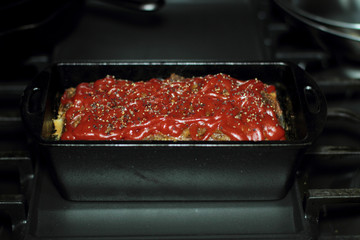 Homemade meatloaf baked in a cast iron loaf pan fresh out of the stove.