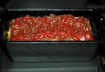Homemade meatloaf baked in a cast iron loaf pan fresh out of the stove.