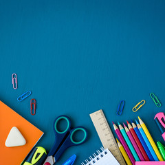 School supplies on blue background. Top view. Copy space.
