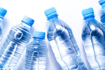 Several plastic water bottles on white background. The concept of plastic free pattern