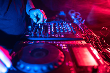 Close up of DJ Hands Controlling Music Table in a Night Club.