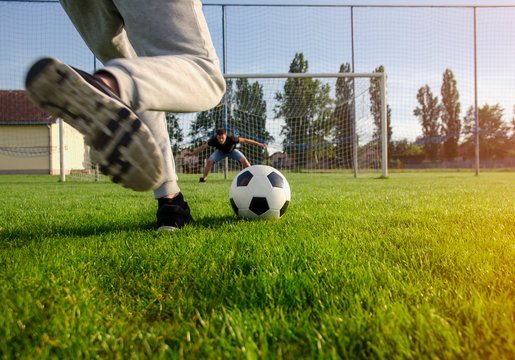 Closeup shot teen preparing to kick the ball , penalty shootout concept 