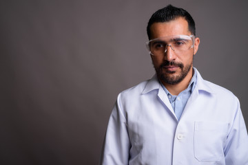 Fototapeta premium Handsome bearded Persian man doctor wearing protective glasses a
