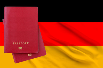 Two passports lying on each other against the background of the flag of Germany, copy space,...